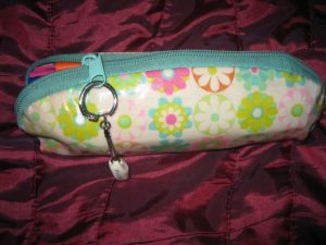 Pencil Case Flower power! It's tiny but holds a lot...that's why I love it. The key ring on the zipper is a porcelain clog from Holland.